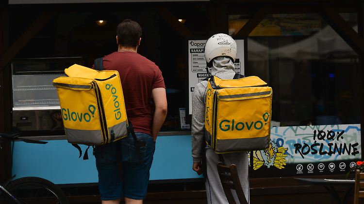 Zwei Glovo-Lieferanten holen im polnischen Krakau eine Bestellung ab.