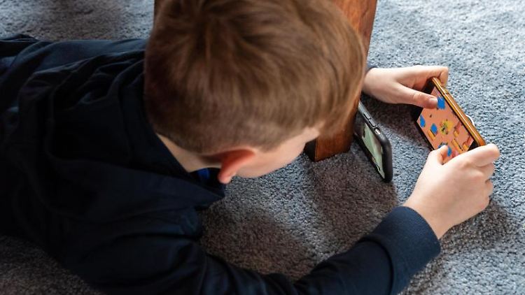 Ein Junge spielt ein Videospiel auf seinem Smartphone. Foto: Robert Michael/dpa-Zentralbild/dpa/Archivbild