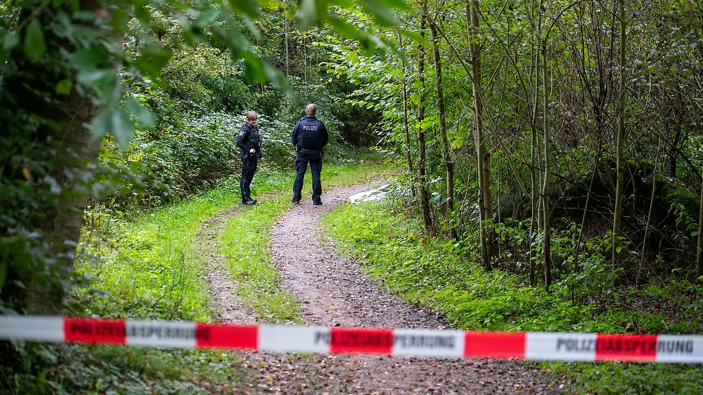Polizisten-stehen-auf-einem-abgesperrten-Waldweg