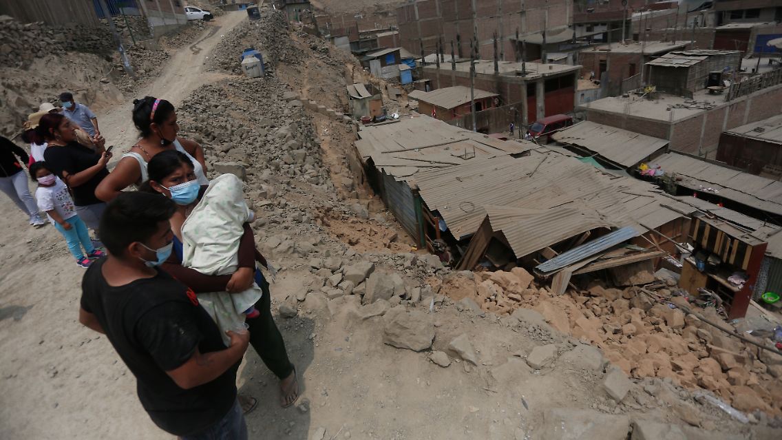 Anwohner stehen nach einem Beben der Stärke 5,6 neben den Schäden in einem Vorort der Hauptstadt.