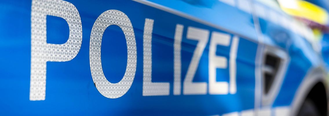 An der Tür von einem Streifenwagen steht der Schriftzug "Polizei".
