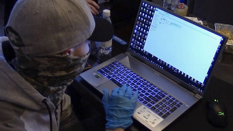 Ein russischer Geheimdienstmitarbeiter präsentiert einen beschlagnahmten Laptop.