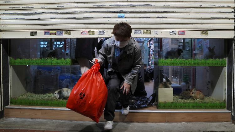 Ein Mann entsorgt einen Sack mit Medizinmüll in Hongkong.