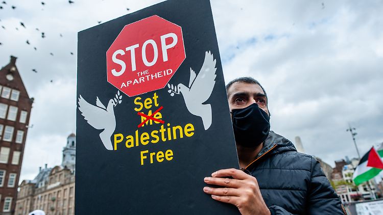 Ein Mann hält bei einer pro-palästinensischen Demo in den Niederlanden ein Schild mit der Aufschrift: Stoppt die Apartheid, befreit Palästina. (Archivbild).