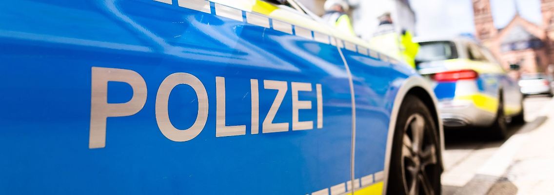 Zwei Einsatzfahrzeuge der Polizei stehen am Straßenrand.