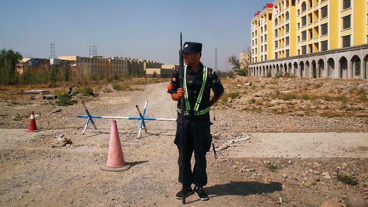 Ein chinesischer Polizist bezieht Stellung in der Nähe eines offiziell als "Berufsbildungszentrum" bezeichneten Gebäudes in Yining.