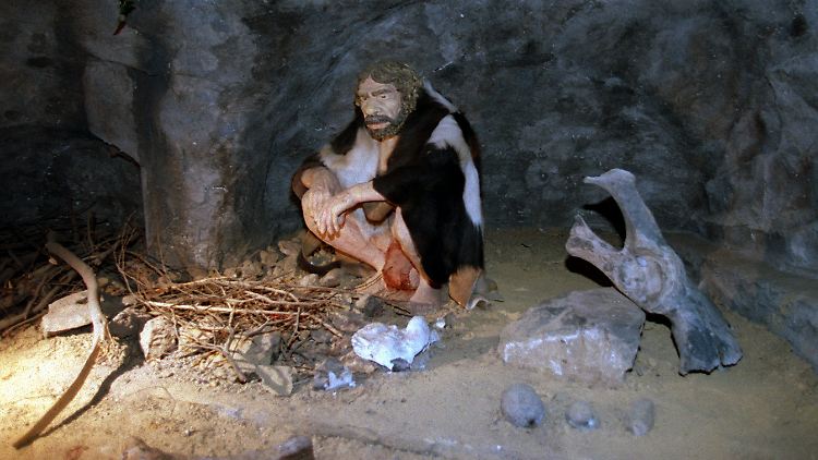 Ein lebensecht nachgebildeter Neandertaler an einer Feuerstelle im Neandertal-Museum in Mettmann.