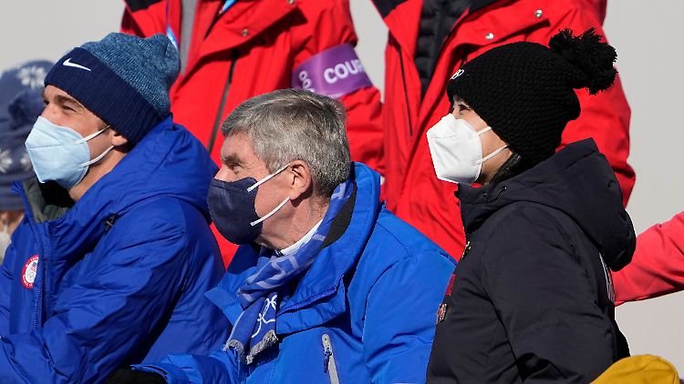 Peng Shuai (r.) schaut gemeinsam mit IOC-Präsident Thomas Bach (m.) das Ski-Freestyle-Finale.