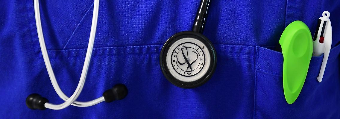 Ein Stethoskop hängt um den Hals eines Arztes.