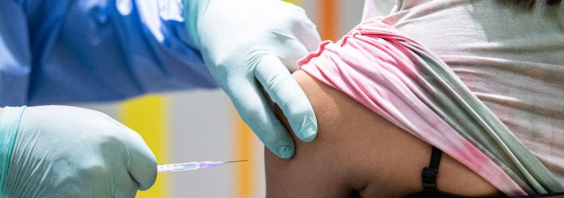 Eine Person wird von einem Impfarzt gegen das Coronavirus geimpft.