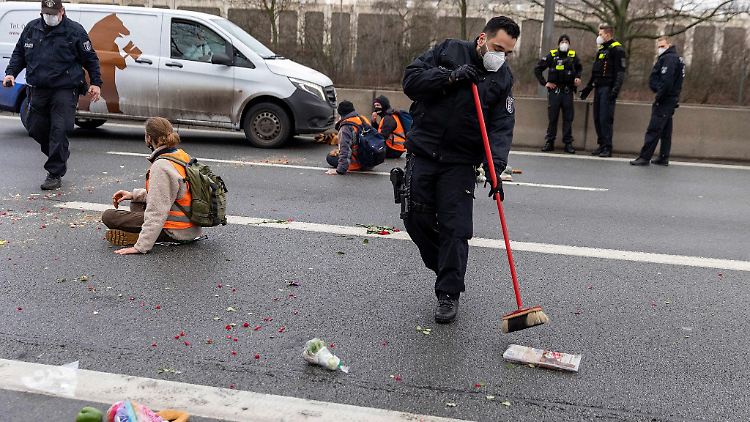 Ein Polizist fegt während einer früheren Blockade Lebensmittel von der Straße.