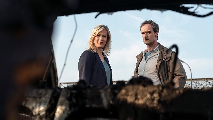 Martina Bönisch (Anna Schudt) und Peter Faber (Jörg Hartmann) betrachten das ausgebrannte Auto ihrer Kollegin.