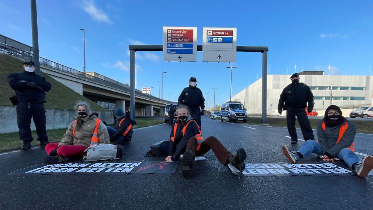 Klimaschutz-Aktivisten der Initiative "Aufstand der letzten Generation" blockieren eine Zufahrt zum Hauptstadt-Flughafen BER.