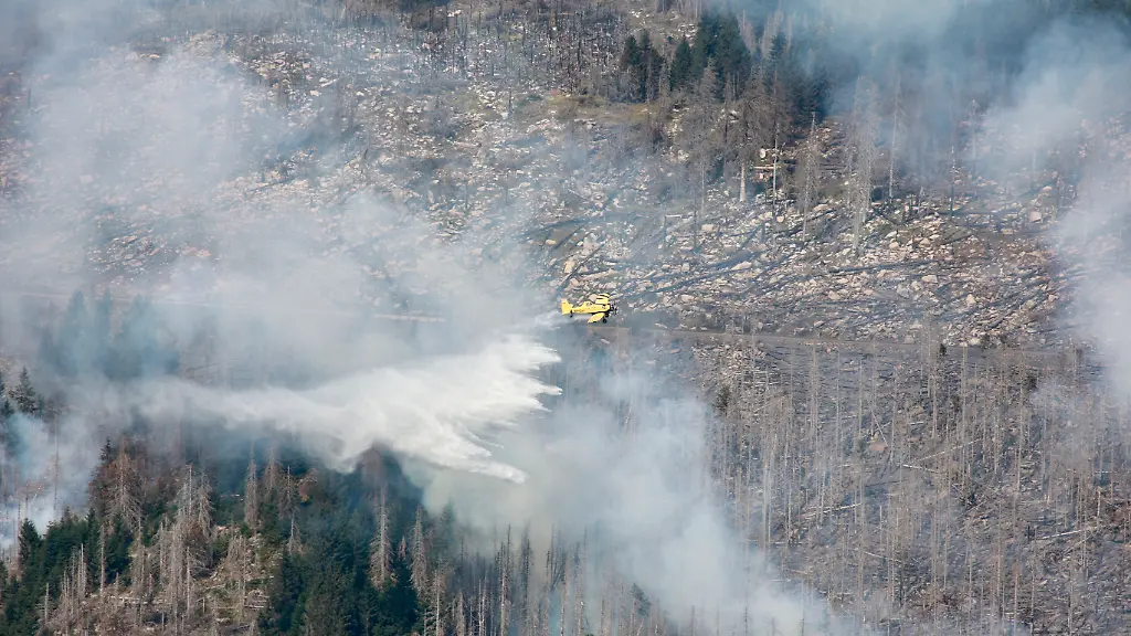 481679200-jpg-Ein-Loeschflugzeug-fliegt-ueber-dem-Koenigsberg-durch-dichte-Rauchwolken-und-wirft-dabei-Wasser-ab-Der-Brand-am-Brocken-im-Harz-hat-sich-weiter-ausgedehnt