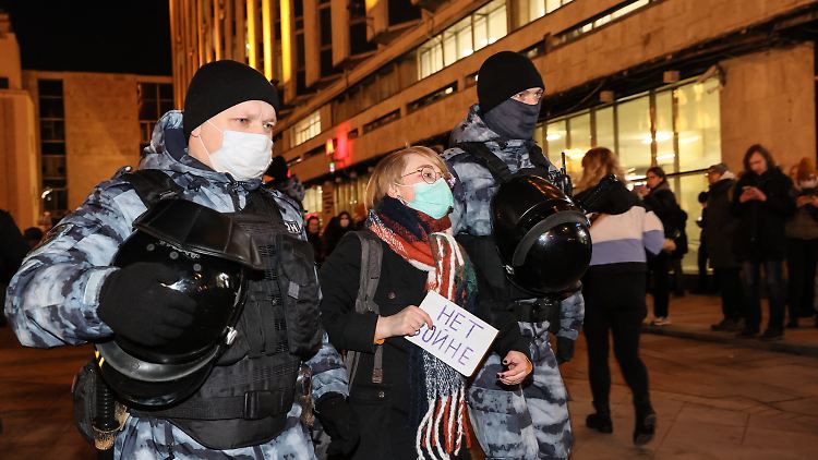 Hier wird eine Demonstrantin eines Antikriegsprotests von russischen Sicherheitskräften festgenommen, sie hält ihr Schild noch in der Hand.