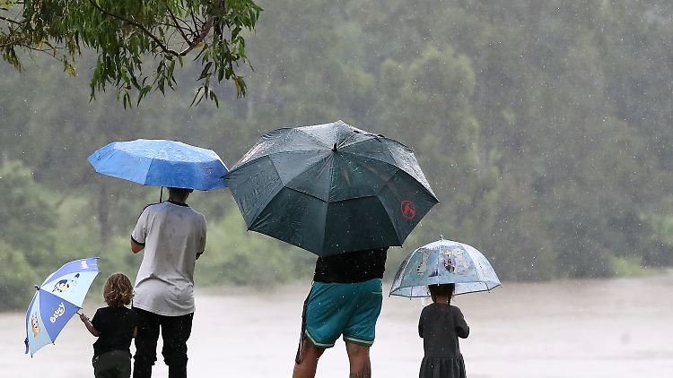 Eine Familie beobachtet das steigende Wasser in Goodna. Die Bewohner des Südostens von Queensland müssen mit heftigeren Regenfällen und lebensbedrohlichen Sturzfluten rechnen.