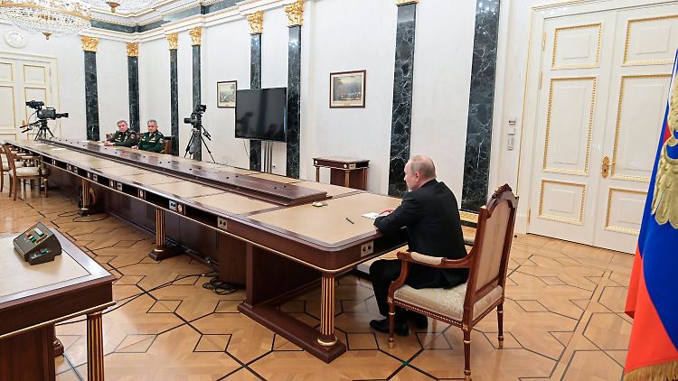 Für seinen Befehl hatte Putin sich einen besonders langen Tisch ausgesucht (links im Hintergrund Verteidigungsminister Schoigu und Generalstabschef Gerassimow).