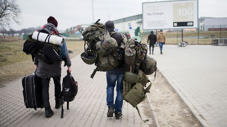 Ein Mann trägt Militärausrüstung an der polnisch-ukrainischen Grenze.