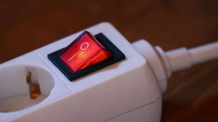 Der eingeschaltete Schutzschalter einer Mehrfachsteckdose leuchtet rot.