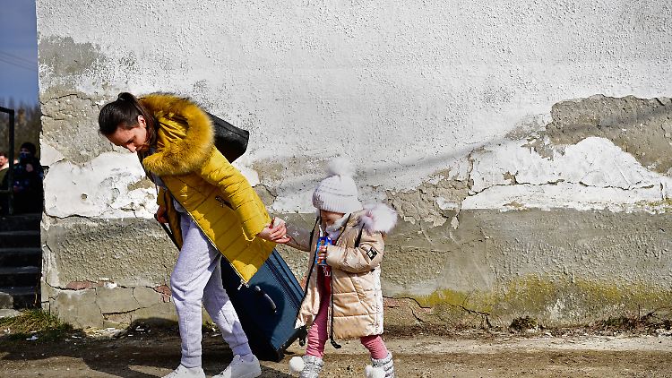 Eine Frau und ein kleines Kind, die vor dem Krieg und dem russischen Angriff aus der Ukraine geflüchtet sind, kommen in der ungarischen Gemeinde Tiszabecs an.
