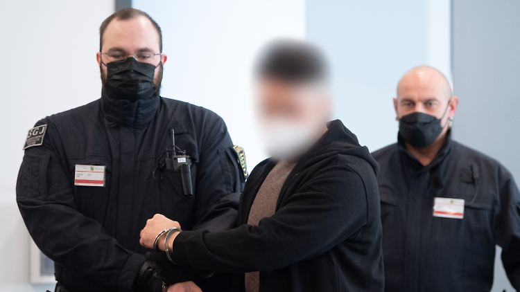 Einer der sechs Angeklagten wird am Dienstag in den Gerichtssaal geführt.