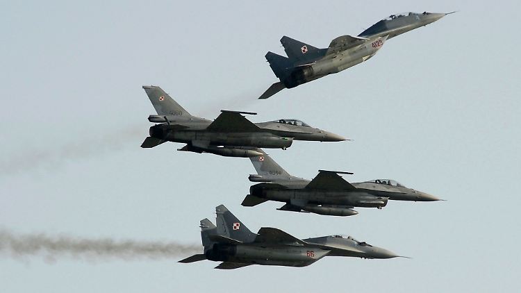 Zwei Mig 29 der polnischen Luftwaffe aus russischer Produktion fliegen über und unter zwei F-16-Kampfjets der polnischen Luftwaffe aus amerikanischer Produktion.
