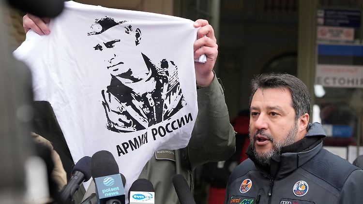 Wojciech Bakun, Bürgermeister von Przemysl, hält ein T-Shirt mit dem Konterfei des russischen Präsidenten Putin hoch, während Matteo Salvini, Vorsitzender der rechten Lega in Italien, mit Journalisten vor dem Bahnhof in Przemysl spricht.