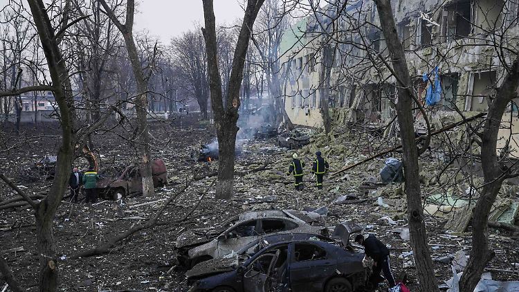 Ukrainische Rettungskräfte gehen an dem Gebäude vorbei, das mal eine Geburtsklinik war.
