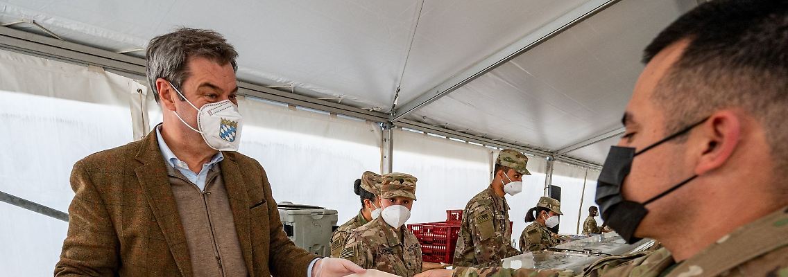 Markus Söder (CSU), Ministerpräsident von Bayern, reicht einem US-Soldaten ein Weißwurstfrühstück.