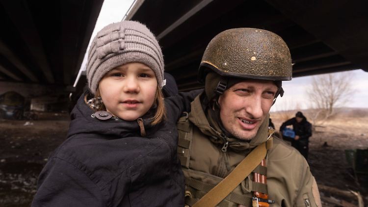 Millionen auf der Flucht: Ein ukrainischer Soldat bringt ein Kind in Sicherheit.