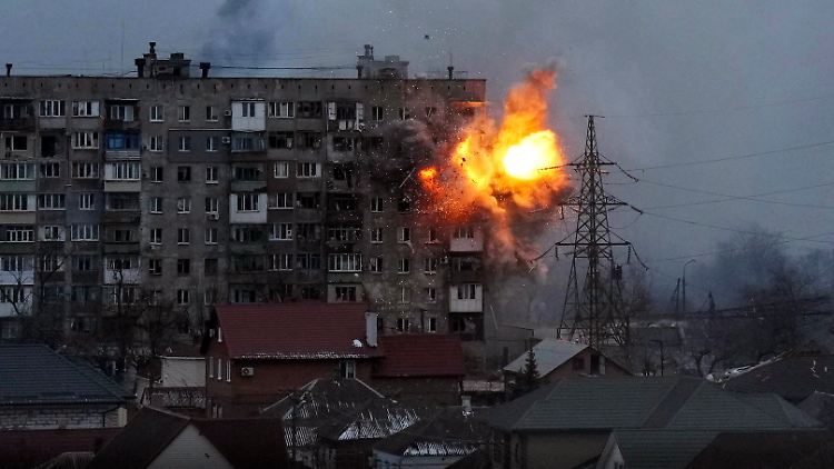 Eine Explosion ist in einem Wohnhaus zu sehen, nachdem ein Panzer der russischen Armee in Mariupol geschossen hat.