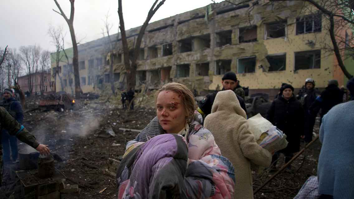 Menschen fliehen aus einem beschossenen Entbindungskrankenhaus in Mariupol.