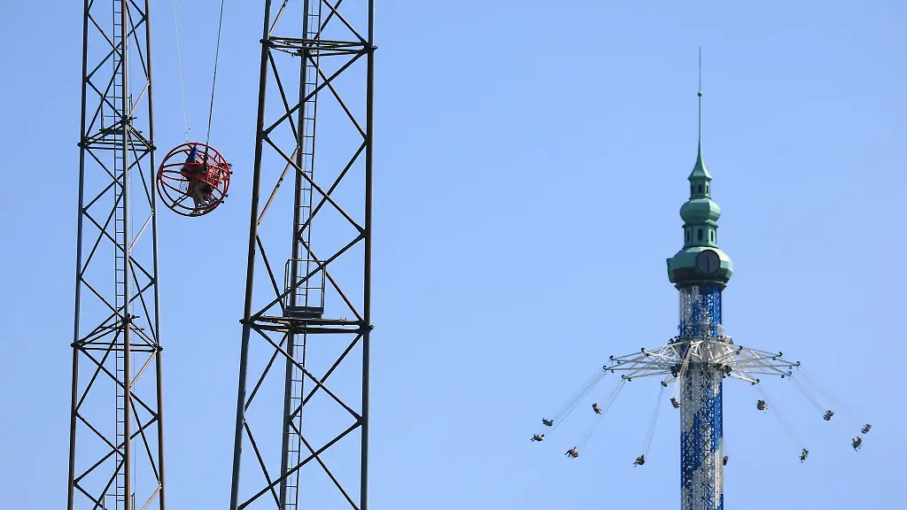 Besucher-des-Freizeitparkes-Allgaeu-Skyline-Park-sitzen-in-dem-Fahrgeschaeft-Sky-Shot-und-dem-Flugkarussell-Allgaeuflieger-Der-Freizeitpark-feiert-derzeit-sein-25-jaehriges-Jubilaeum