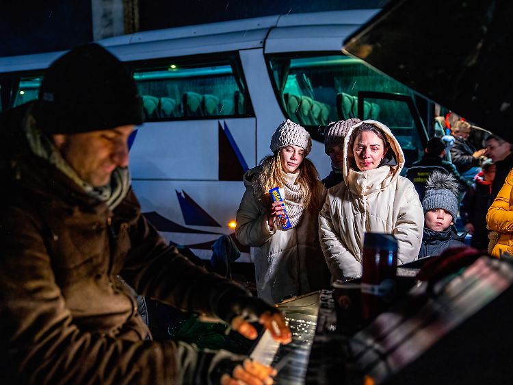 Polen, Medyka: Ein Freiwilliger spielt an der Grenze Klavier für Flüchtlinge.