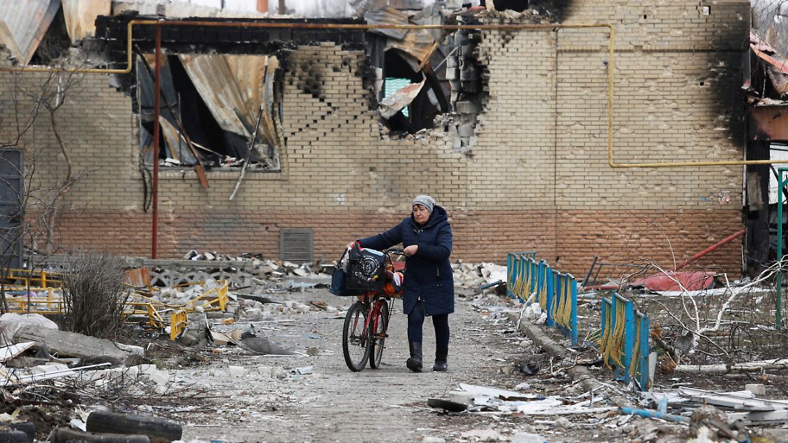 Eine Frau schiebt ihr Fahrrad durch die Straßen von Volnovakha, das in der Ostukraine liegt.
