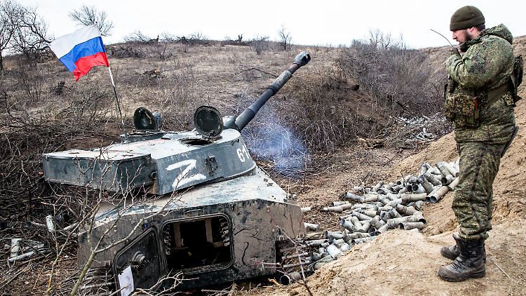 Ein Milizionär aus Luhansk in der Nähe von Popasna neben einem russischen Panzer.
