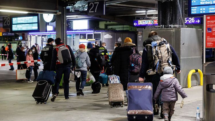 Zahlreiche Flüchtlinge aus der Ukraine gehen nach ihrer Ankunft aus der Ukraine zur Registrierung am Münchner Hauptbahnhof.