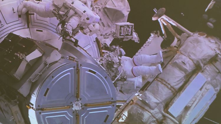 Matthias Maurer und Raja Chari (v.l.), bei ihrem ISS-Außenbordeinsatz auf einer Leinwand im Deutschen Zentrum für Luft- und Raumfahrt (DLR) im Columbus-Kontrollzentrum zu sehen.