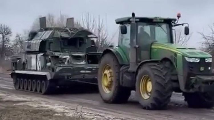 Ein ukrainischer Bauer nimmt mit seinem Traktor einen erbeuteten russischen Panzer ins Schlepptau.