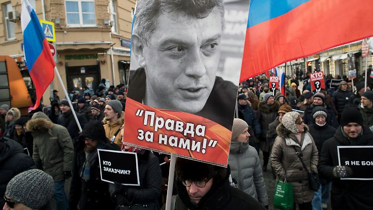 Bei einem Gedenken trägt ein Mann ein Bild des ermordeten Oppositionsführers Boris Nemzow.