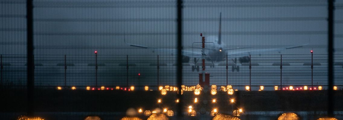 Ein Flugzeug landet hinter Signallichtern auf dem Flughafen Frankfurt. Die Flughafengesellschaft Fra