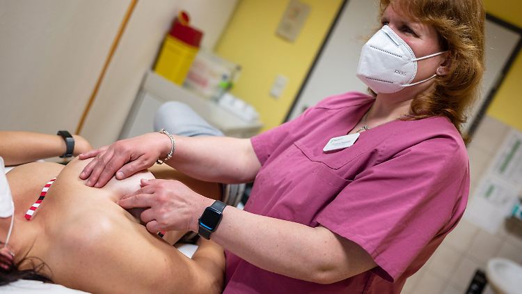 Die blinde Medizinisch-Taktile Untersucherin (MTU) Christine Kanetzki untersucht an der Paracelsus-Klinik Reichenbach die Brust einer Patientin. Die Spezialklebestreifen dienen der MTU als Orientierung, während die Brust nach einem standardisierten Verfahren in allen Gewebetiefen systematisch abgetastet wird.