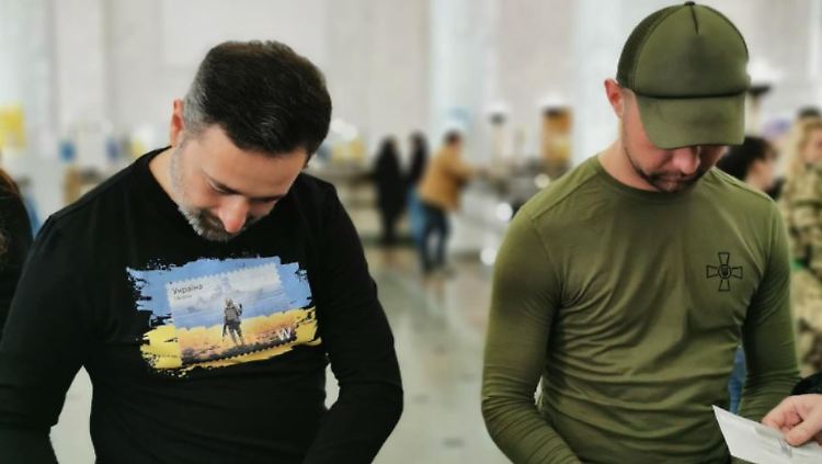 Der ukrainische Soldat Roman Hrybow (rechts) und Postchef Ihor Smyljanskyj signieren im Hauptpostamt die neuen speziellen Briefmarken.