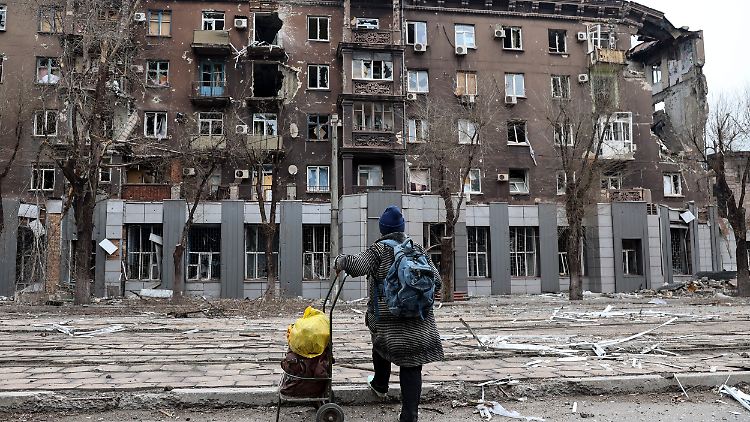 Eine Anwohnerin betrachtet ein bei schweren Kämpfen beschädigtes Wohnhaus in einem von den von Russland unterstützten Separatisten kontrollierten Gebiet in Mariupol.