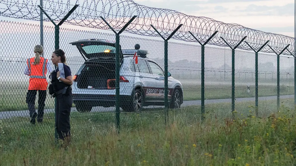 Nach-Angaben-der-Brandenburger-Landespolizei-haben-sich-zwei-Menschen-auf-dem-Flughafengelaende-festgeklebt