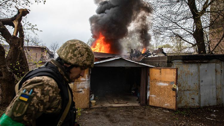 Ein ukrainischer Soldat nach einem russischen Artillerieangriff vor einer brennenden Garage. Das Bild entstand am Montag.