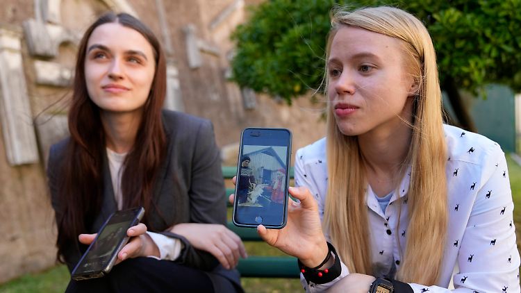Julia Fedosiuk und Kateryna Prokopenko (r.), Ehefrauen von Asow-Kämpfern, zeigen Fotos ihrer Männer.