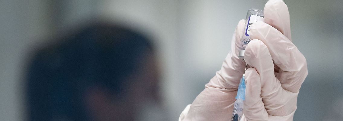 Eine Frau zieht eine Dosis des Corona-Impfstoffes von Biontech/Pfizer auf.
