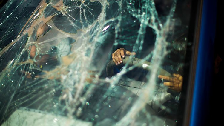 Ein Kind spielt am Lenkrad eines Autos, dessen Windschutzscheibe zersplittert ist, nachdem es gemeinsam mit seiner Familie aus Mariupol in einem Aufnahmezentrum für Kriegsflüchtlinge in Saporischschja angekommen ist.