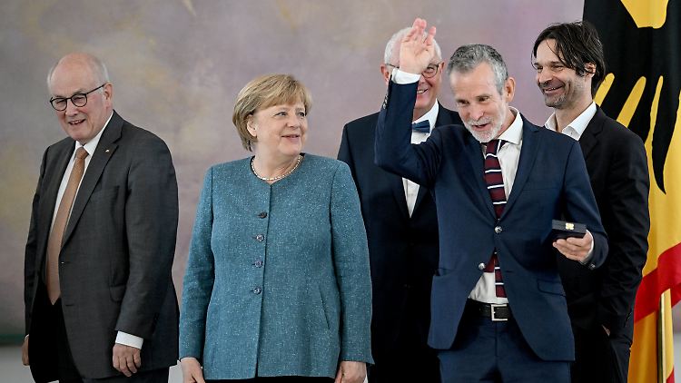 Angela Merkel ohne Raute, Ulrich Matthes winkt.